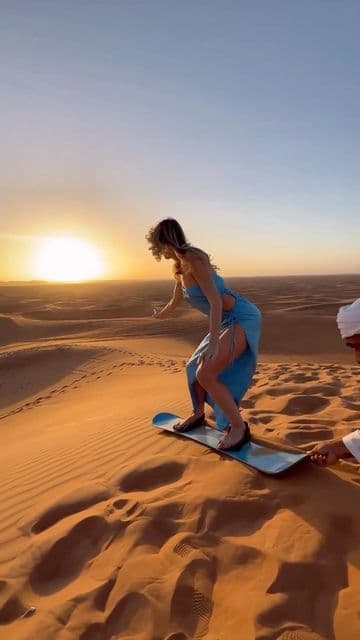 A sandboard resting on the red dunes of the Dubai desert