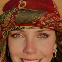 Close portrait of a smiling guest wearing a traditional embroidered headscarf